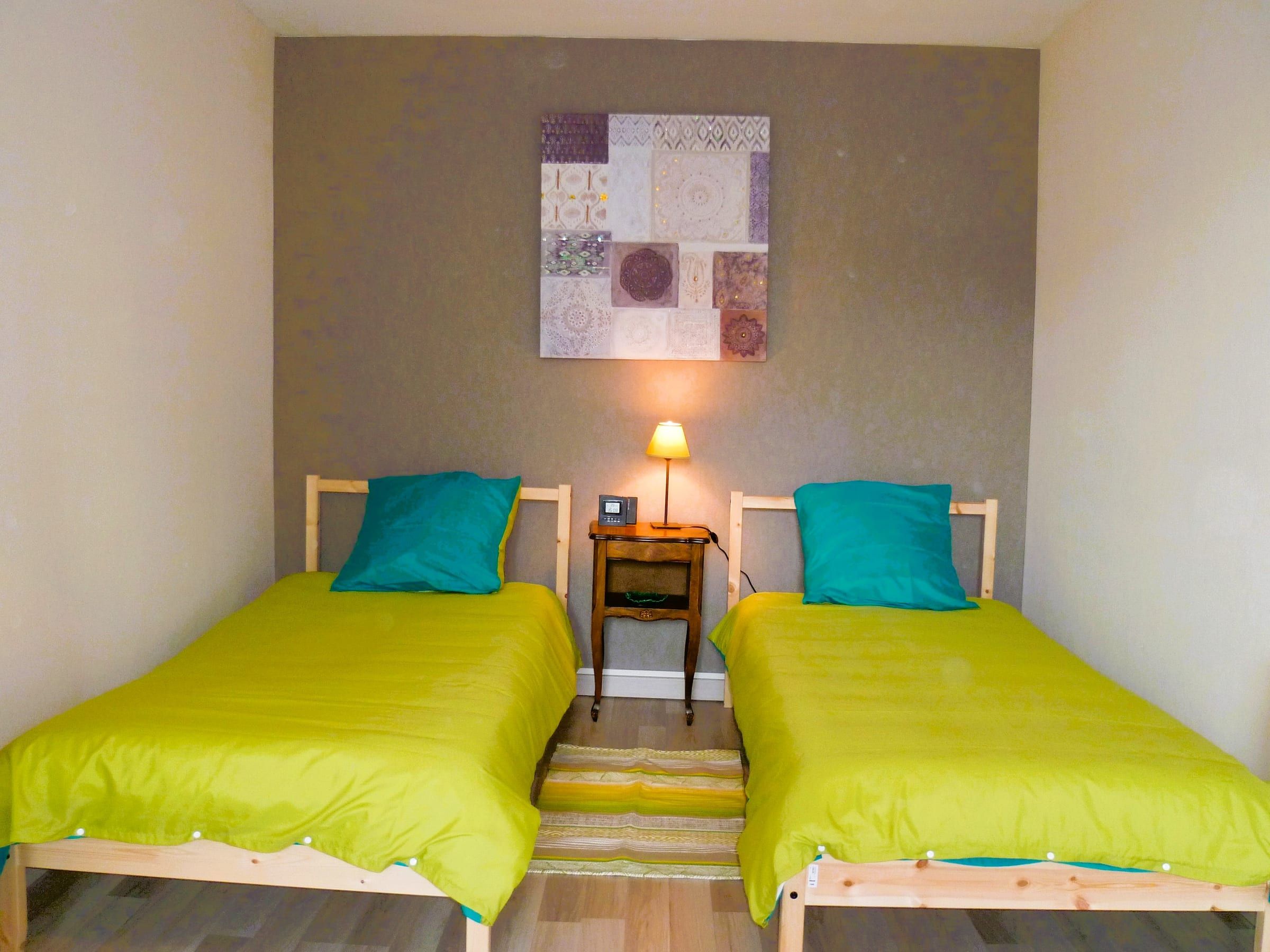 Chambre avec deux lits jumeaux et linge turquoise